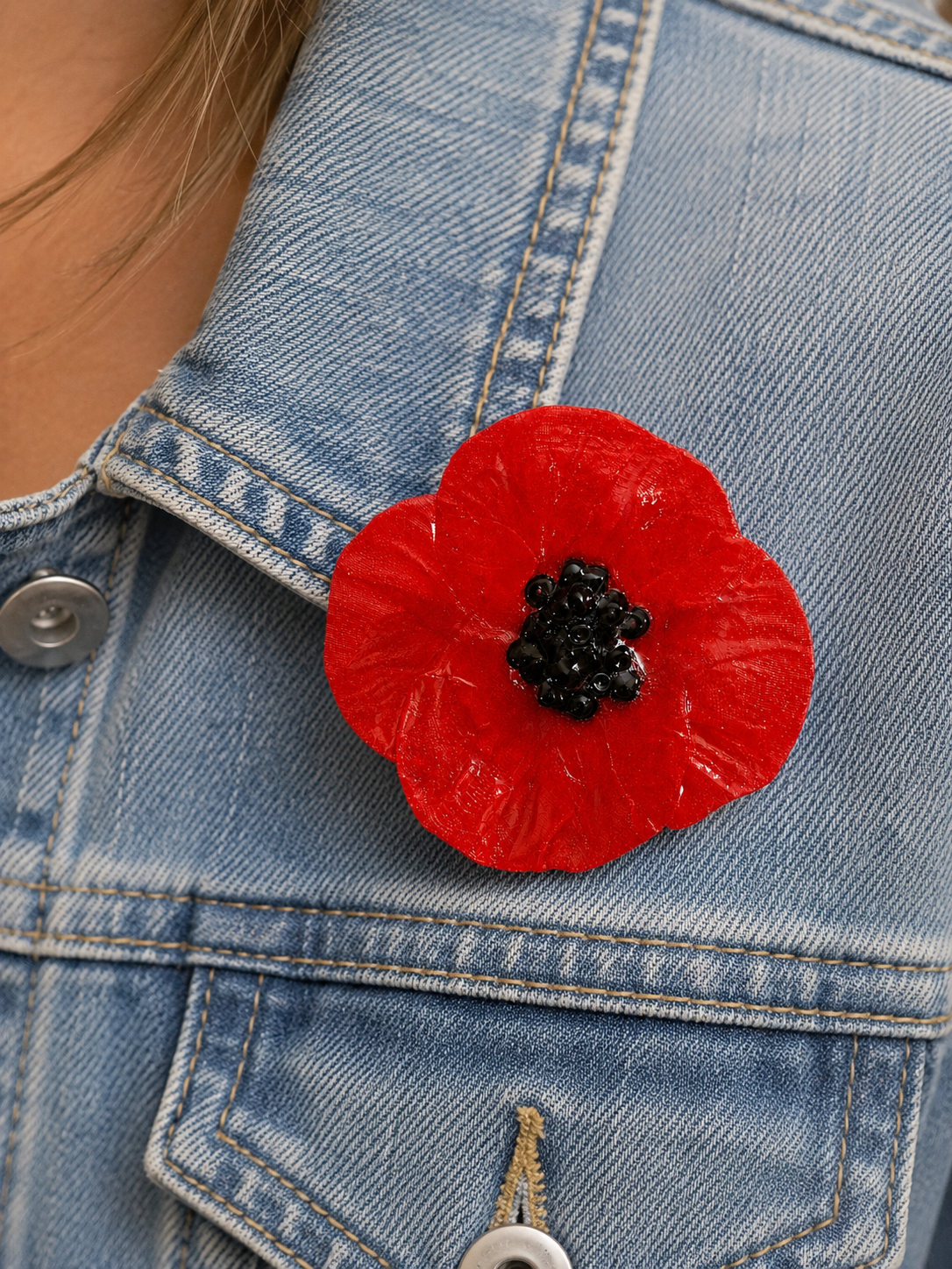 Broche coquelicot à épingle avec fermeture sécurisée portée sur une veste en jean