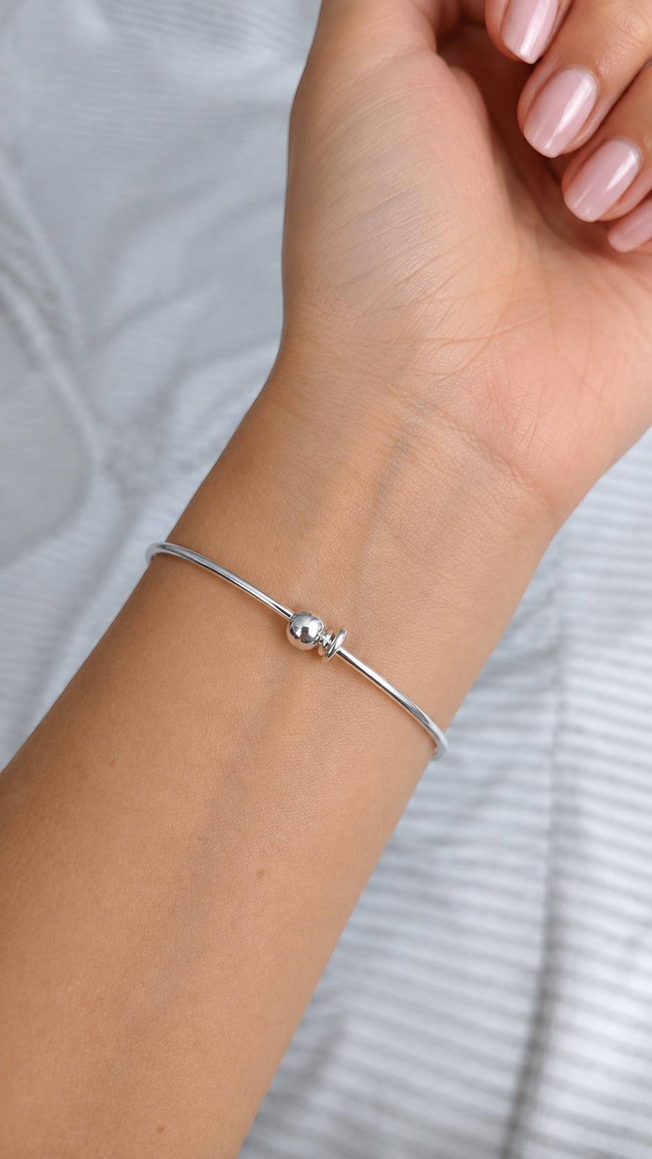 Bracelet jonc coquelicot rouge en acier inoxydable porté au poignet